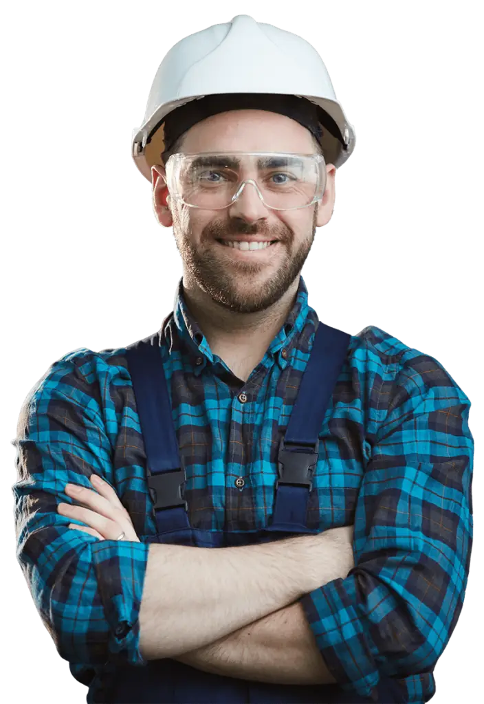 Smiling home service worker in a hard hat and safety glasses with arms crossed.